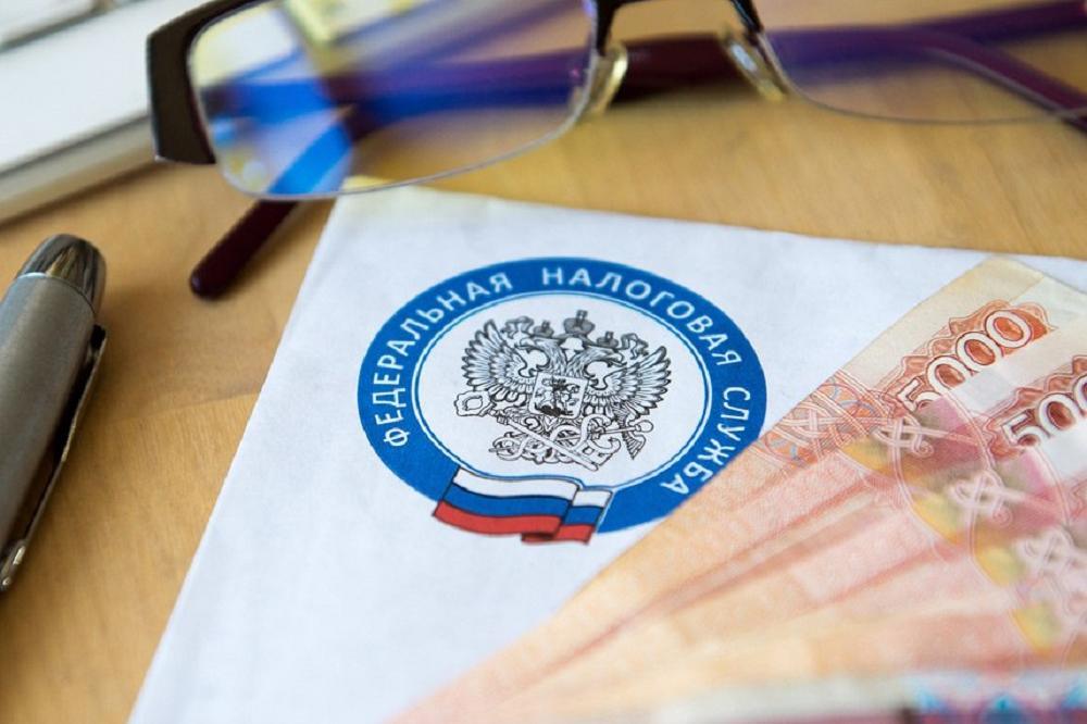 Документ с эмблемой Федеральной налоговой службы России, купюры 5000 рублей, ручка и очки на рабочем столе